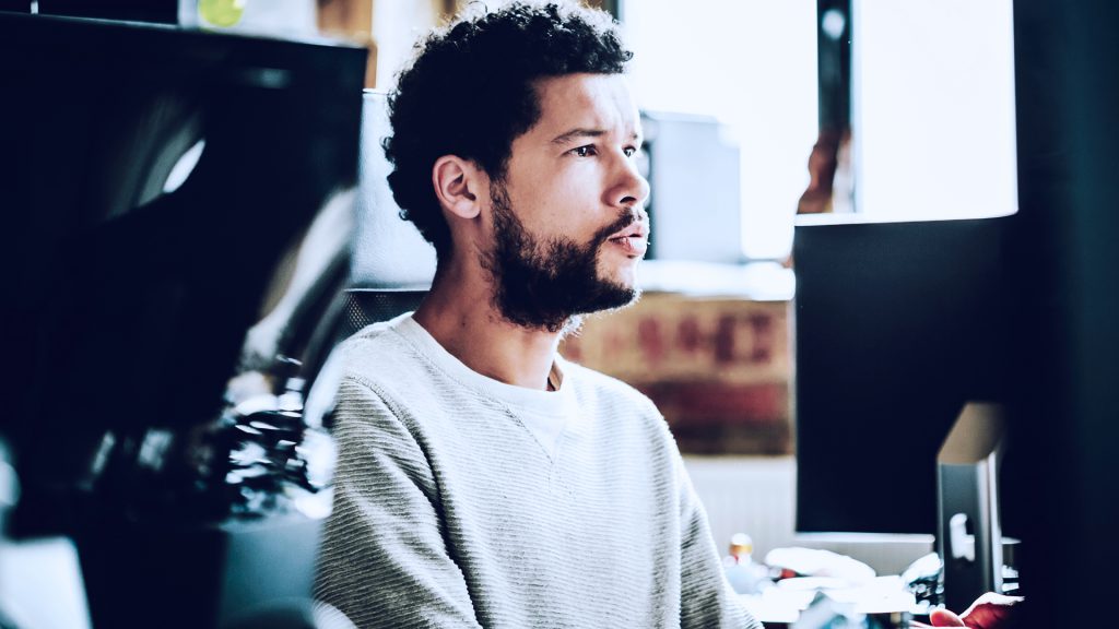 Foto de homem concentrado, usando um computador.