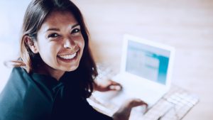 imagem com mulher mechendo em computador, representando uma solução de marketing de afiliados